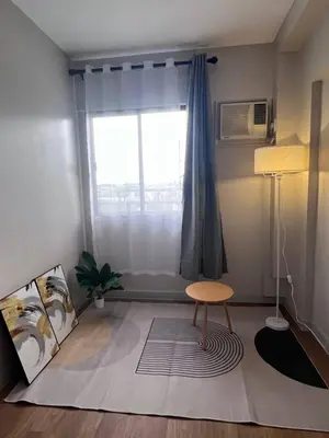 a living room with a chair and a window at Resort inspired Alea residences in Manila
