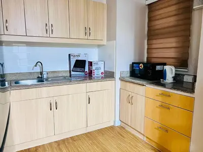 a kitchen with wooden cabinets and a sink at Resort inspired Alea residences in Manila