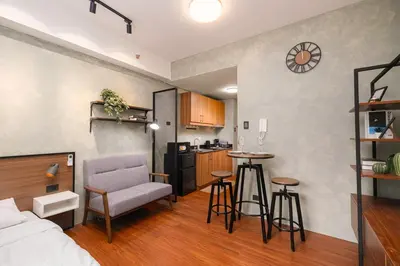 a living room with a bed and a kitchen at SMDC Lush The Forge in Manila