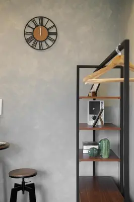a shelf with a clock on the wall and a stool at SMDC Lush The Forge in Manila