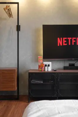 a bedroom with a netflix sign on the wall at SMDC Lush The Forge in Manila