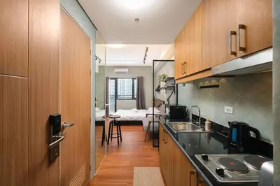 a kitchen with a sink and a room with a bed at SMDC Lush The Forge in Manila