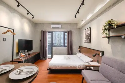a hotel room with a bed and a tv at SMDC Lush The Forge in Manila