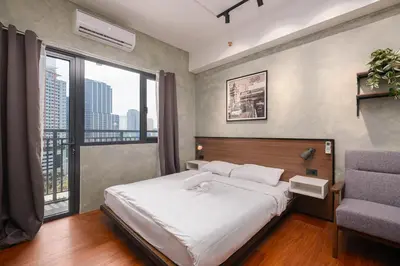 a bedroom with a large bed and a window at SMDC Lush The Forge in Manila