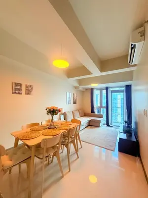 a living room with a table and chairs and a couch at Spacious 2 Bedroom with StunningView in Uptown BGC in Manila