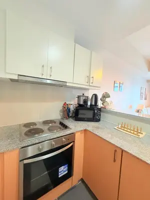 a kitchen with a stove and a microwave at Spacious 2 Bedroom with StunningView in Uptown BGC in Manila