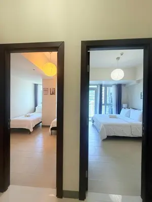 a bedroom with two beds and a mirror at Spacious 2 Bedroom with StunningView in Uptown BGC in Manila