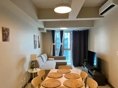a living room with a table and a couch at Spacious 2 Bedroom with StunningView in Uptown BGC in Manila