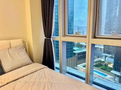 a bedroom with a bed and a large window at Bright Corner 2BR Suite with Bathtub Uptown BGC in Manila