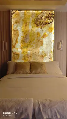 a bed in a bedroom with a painting on the wall at Golden Luxe Staycation Studio in Manila