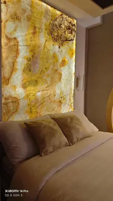 a bedroom with a painting on the wall next to a bed at Golden Luxe Staycation Studio in Manila