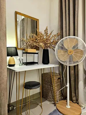 a room with a table with a fan and a mirror at Irene's luscious place in Manila
