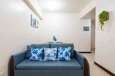 a blue couch with blue pillows in a room at fairlane 1bed room in Manila