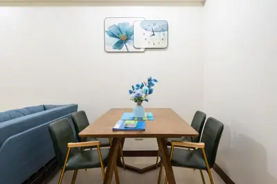 a dining room table with chairs and a blue couch at fairlane 1bed room in Manila