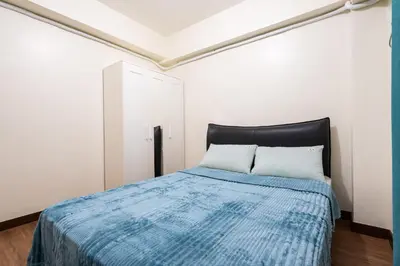 a bedroom with a bed with a blue blanket at fairlane 1bed room in Manila
