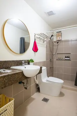 a bathroom with a sink and a toilet and a mirror at fairlane 1bed room in Manila