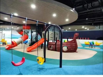 a childrens play area with a slide and swings at Modern Minimalist City Views in Prime Location in Manila