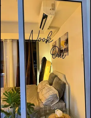 a reflection of a couch in a store window at Nook Out at Azure Urban Residences in Manila