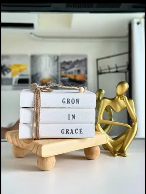 a stack of books sitting on top of a wooden table at Nook Out at Azure Urban Residences in Manila