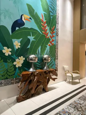 a painting of a bird on a wall next to a table at Nook Out at Azure Urban Residences in Manila