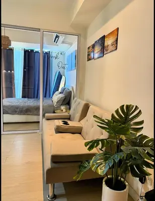 a living room with a couch and a mirror at Nook Out at Azure Urban Residences in Manila