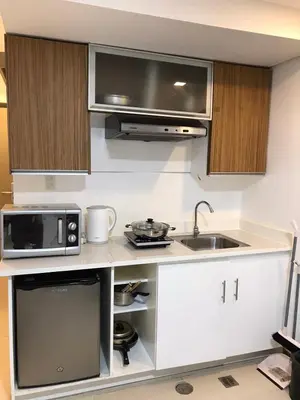a kitchen with a sink and a microwave at Antel Spa Residences 10B in Manila