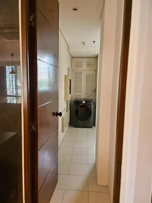 a hallway with a door to a room with a washing machine at 2 Bedroom Urban Oasis Poblacion in Manila