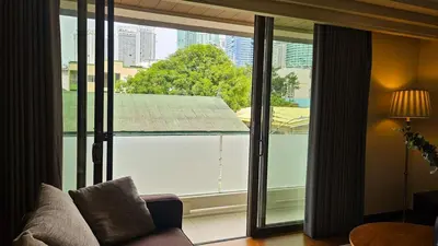 a living room with a large glass window with a couch at 2 Bedroom Urban Oasis Poblacion in Manila