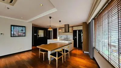 a kitchen and dining room with a wooden table and chairs at 2 Bedroom Urban Oasis Poblacion in Manila