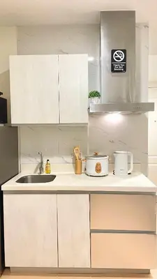 a kitchen with white cabinets and a sink at La Luana Mnl in Manila