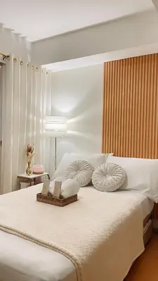 a bedroom with a large white bed with two pillows at La Luana Mnl in Manila