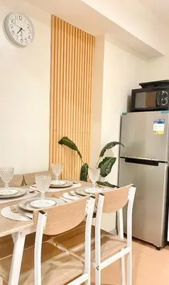 a dining room with a table and a refrigerator at La Luana Mnl in Manila