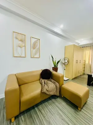 a living room with a brown couch and a table at Cozy Haven in Manila