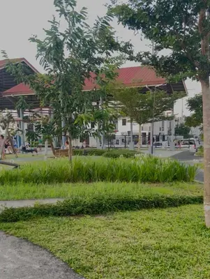 a park with trees and a building in the background at Von Home Sweet Home in Dasmariñas