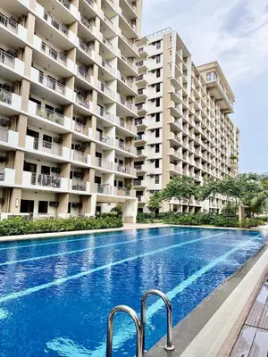 a swimming pool in front of a large apartment building at YourSafeHaven Calathea Place Lavender Bldg in Manila