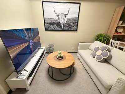 a living room with a couch and a cow on the wall at Aesthetic Cozy Modern Condo Apartment in Manila