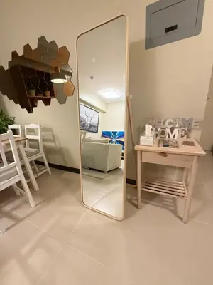 a mirror in a living room with a table and a couch at Aesthetic Cozy Modern Condo Apartment in Manila