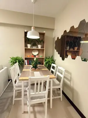 a dining room with a table and white chairs at Aesthetic Cozy Modern Condo Apartment in Manila
