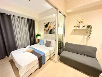 a bedroom with two beds and a chair in it at 1BR Condotel in Azure Urban Resort Near NAIA #BH1 in Manila
