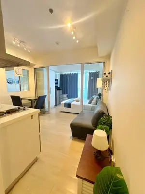 a kitchen and a living room with a couch and a table at 1BR Condotel in Azure Urban Resort Near NAIA #BH1 in Manila