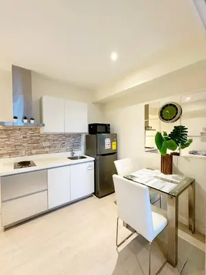 a kitchen with a table and a refrigerator at 1BR Condotel in Azure Urban Resort Near NAIA #BH1 in Manila
