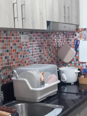 a kitchen sink with a feeding container on the counter at Condotel-Coast Residences in Manila