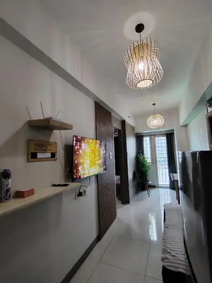 a living room with a flat screen tv on a wall at Condotel-Coast Residences in Manila