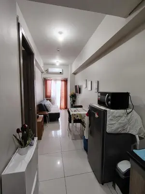 a kitchen and living room with a refrigerator and a table at Condotel-Coast Residences in Manila