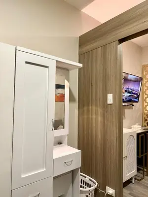 a bathroom with a white cabinet and a tv at Tres Casa in Manila