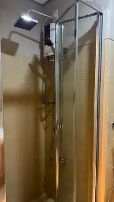 a shower with a glass door in a bathroom at Tres Casa in Manila