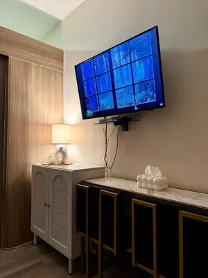 a flat screen tv hanging on a wall at Tres Casa in Manila