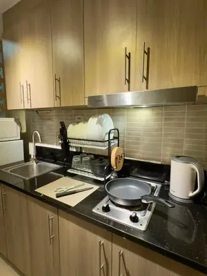 a kitchen with a stove with a pan on it at Tres Casa in Manila