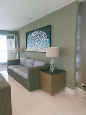 a living room with a couch and a table with a lamp at Rdhee Condotel NEAR SMX MOA in Manila