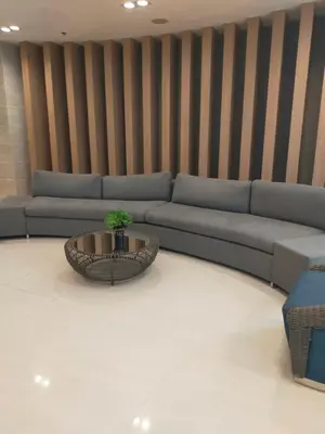 a living room with a blue couch and a table at Rdhee Condotel NEAR SMX MOA in Manila